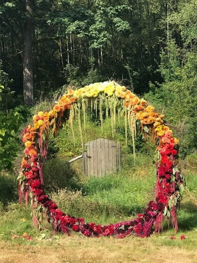 Floral arch featuring dahlias in red, yellow and orange