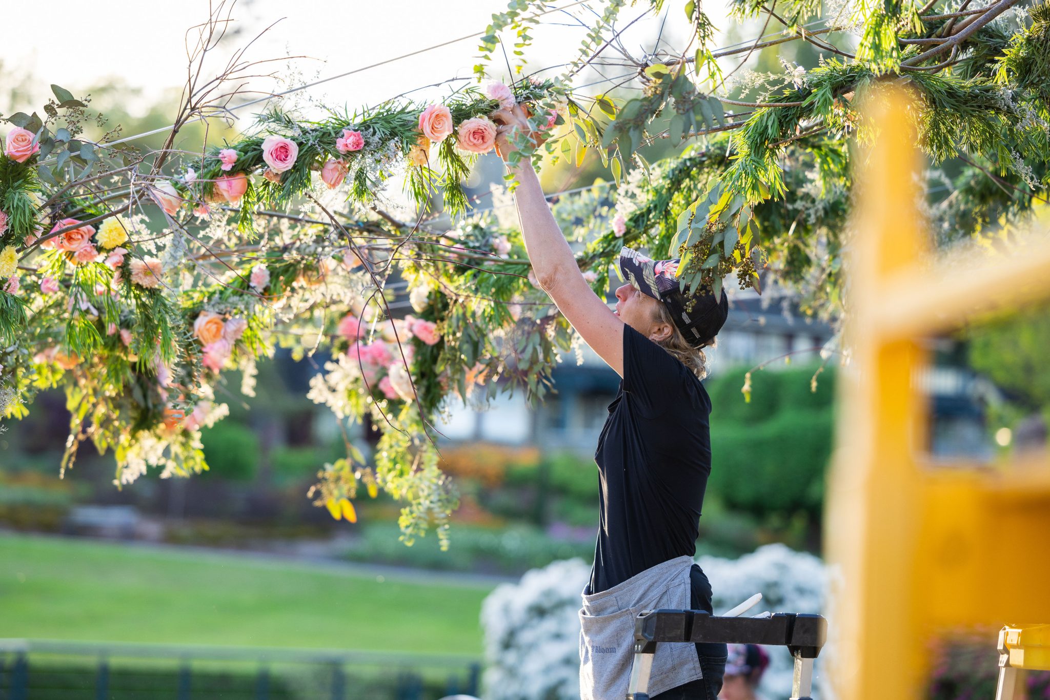 Floral designer, Alexandra Richards, works on a floral arch. 